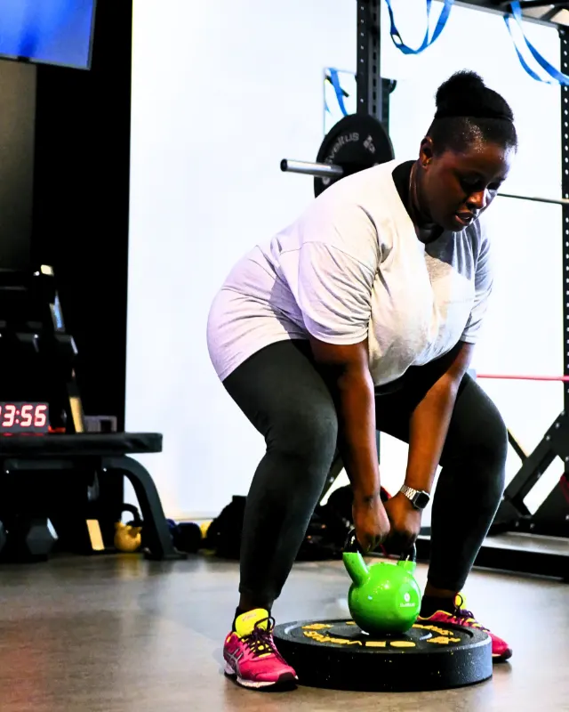 Une adhérente réalise un exercice au kettlebell