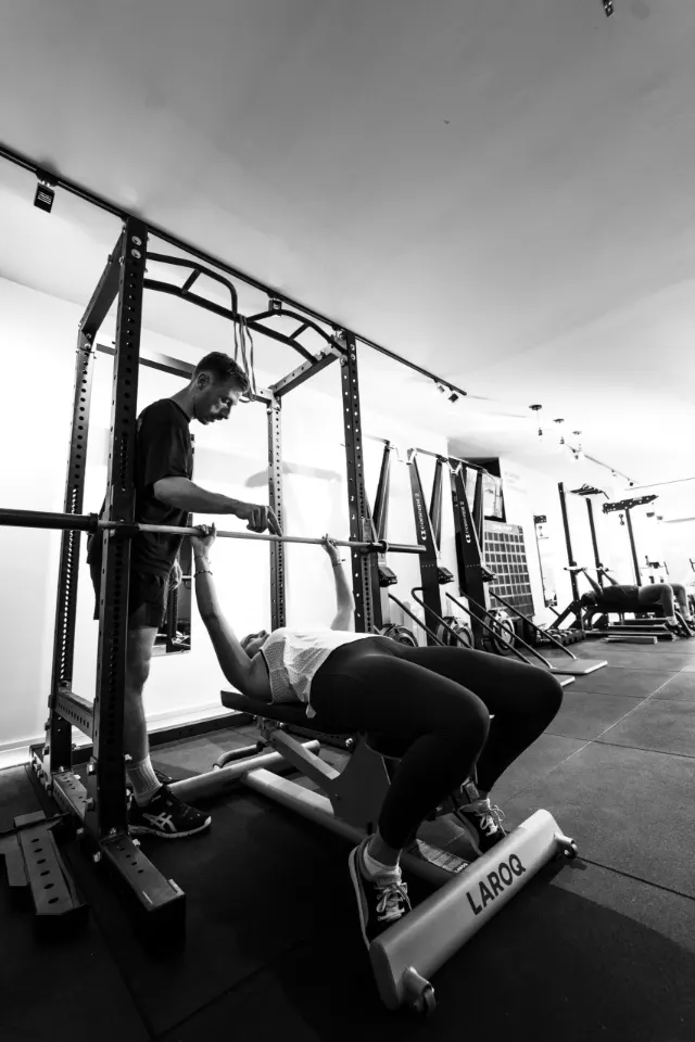 Séance de musculation encadrée au club, en noir et blanc